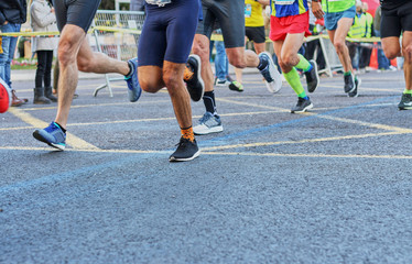 Fototapeta premium Marathon race, feet of people running on city road