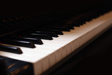 Hands on piano. The pianist plays the piano. Piano keys on black background