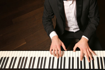 Hands on piano. The pianist plays the piano. Piano keys on black background