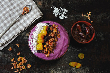 Fototapeta premium Bright purple breakfast bowl. Colorful healthy superfood in the style of flat lay.