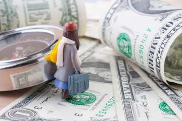 Miniature girl walking on paper dollar currency