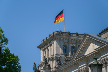 German flag on tower, top of Reichstag building in Berlin, Germany.