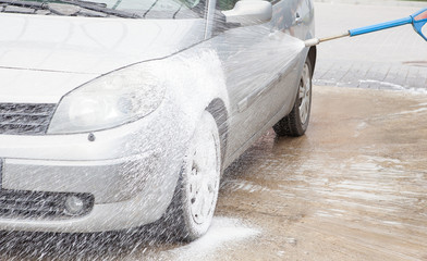 Car wash with foam in car wash station. Carwash. Washing machine at the station. Car washing...