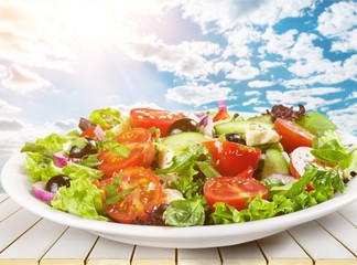 Greek salad with fresh vegetables on background