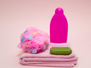 Obraz na płótnie Canvas set of woman aroma therapy shower preparing equipment like towel, puffy sponge, green fruit aroma soap and shampoo on pink background