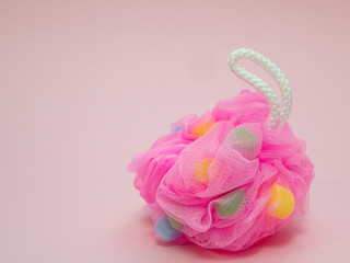 closeup fancy fluffy pink sponge on pink background with colored inserts