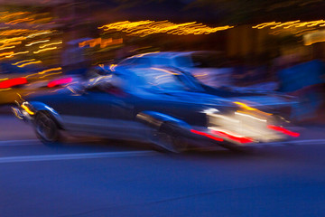 Fototapeta na wymiar Impressions of a Car Speeding By City Neon Lights