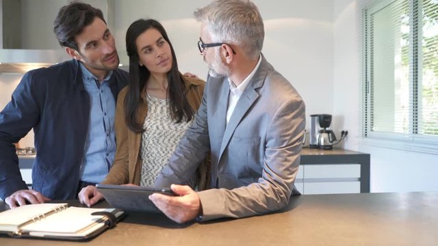 Real estate agent looking over details on tablet with future homeowners