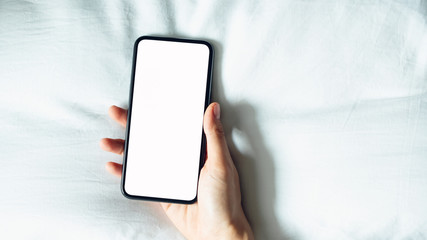 hand using blank screen of smartphone on room, During leisure time. The concept of using the phone is essential in everyday life.