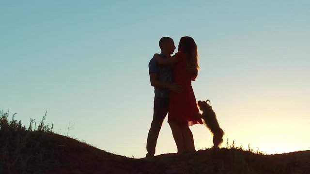 silhouette of a happy young married couple and dog slow dancing outside at sunset. slow motion video. man and girl dancing salsa at sunset. Unidentifiable Silhouette of dancing couple love friendship