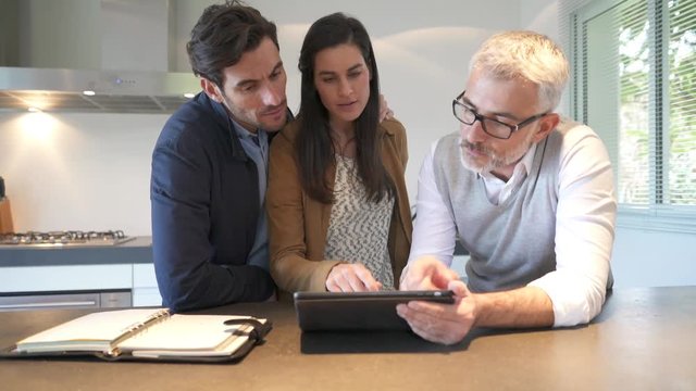 Kitchen rep going through specs on tablet with couple in showroom