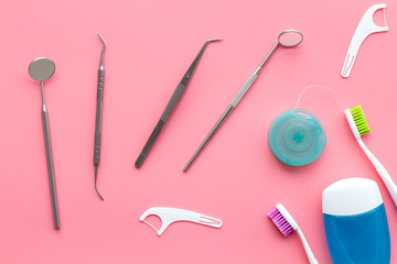 Daily oral hygiene for family. Toothbrush, dental floss and dentist instruments on pink background...