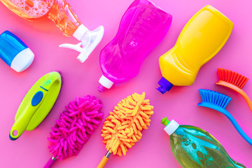 Housekeeping tool. Detergents, soap, cleaners and brush for housecleaner work on pink background top view space for text