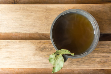 Hot tea in a mug from a thermos with a birch leaf in a bath
