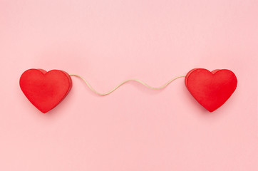 Pair of red hearts connected with a string of twine - obrazy, fototapety, plakaty