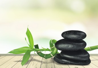 Obraz na płótnie Canvas Zen basalt stones and leaves on desk