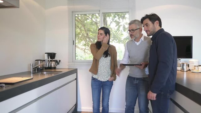 Kitchen salesman pitching to potential buyer couple in showroom