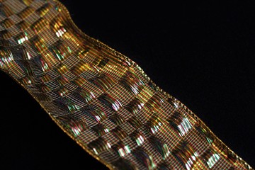 Close up gold and multicolored thread gift wrapping ribbon