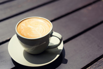Hot art Latte Coffee in a cup on wooden table in Coffee shop.