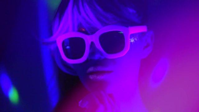 Fashion model woman in neon light. Beauty girl with fluorescent makeup. Party at night club. Slow motion 4K UHD video footage. 3840X2160