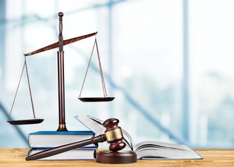 Man with glasses folded his arms and book, hammer and libra