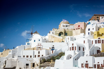Fototapeta premium Traditional houses and windmill on the cliff against sky; Santorini; Greece