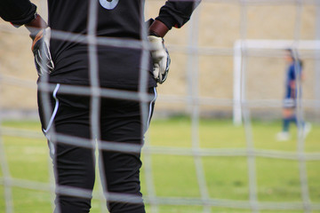 Portera con traje negro y guantes parada en la portería