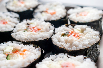 Chumaki Sushi Rolls with Tuna, Salmon, Rice, Cucumber, Avocado And Nori Seaweed on a Plate.