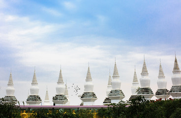 White pagoda and a flock of flying pigeons - 238656879