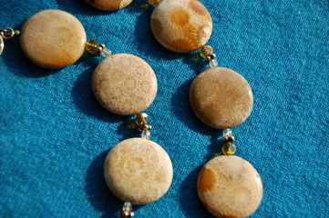Golden stones linked with beads on blue textured background