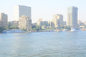 Fototapeta na wymiar Nile river in Cairo Egypt during the day with boats running and high building surrounding river banks
