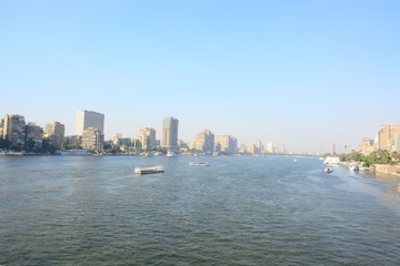  Nile river in Cairo Egypt during the day with boats running and high building surrounding river banks