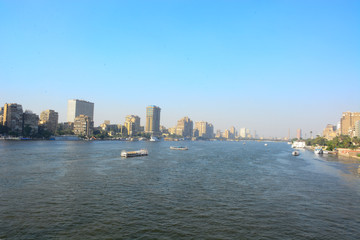  Nile river in Cairo Egypt during the day with boats running and high building surrounding river banks