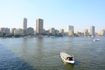  Nile river in Cairo Egypt during the day with boats running and high building surrounding river banks