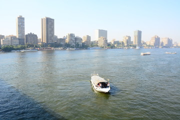 Nile river in Cairo Egypt during the day with boats running and high building surrounding river banks