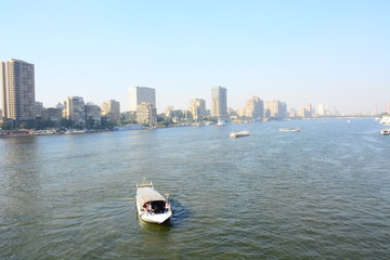  Nile river in Cairo Egypt during the day with boats running and high building surrounding river banks