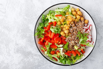 Healthy and delicious bowl with buckwheat and salad of chickpea, fresh pepper and lettuce leaves. Dietary balanced plant-based food. Vegan and vegetarian dish. Top view. Flat lay
