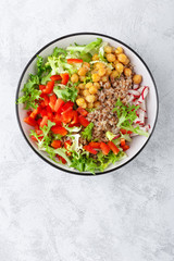Healthy and delicious bowl with buckwheat and salad of chickpea, fresh pepper and lettuce leaves. Dietary balanced plant-based food. Vegan and vegetarian dish. Top view. Flat lay