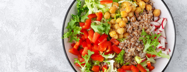 Healthy and delicious bowl with buckwheat and salad of chickpea, fresh pepper and lettuce leaves. Dietary balanced plant-based food. Vegan and vegetarian dish. Top view. Flat lay