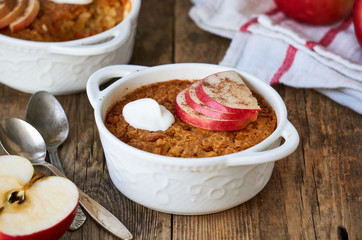 Rice casserole with apples and carrots on a wooden background