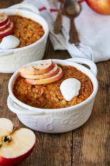Rice casserole with apples and carrots on a wooden background