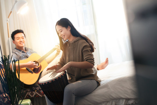Happy couples playing Musical Instruments at home