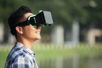 Smiling young man in vr headset trying new application