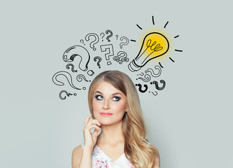 Happy young woman student with lightbulb and question marks. Brainstorm, problem and solution concept