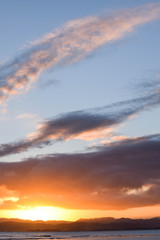 Fototapeta premium Clear cloud shaped surround the sunset above the beach in Gisborne, New Zealand.