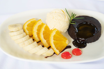 Chocolate cake lava with well decorated orange and banana and ice cream