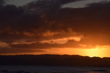 A dark sunset sky above a darkening hill landscape in Gisborne, New Zealand.