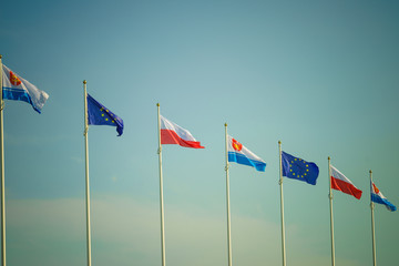 Flags of Poland, European Union city Gdynia against sky