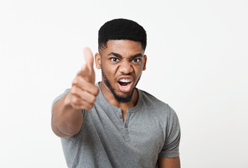 Fototapeta premium Angry furious young black man, screaming and pointing