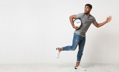 African-american man running with big alarm clock